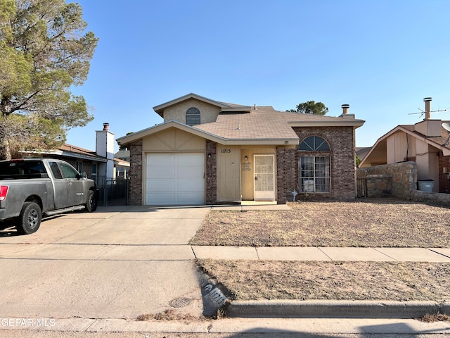 11713 Francis Scobee Dr, El Paso, TX 79936 - view of front of home featuring a garage, concrete driveway, and brick siding