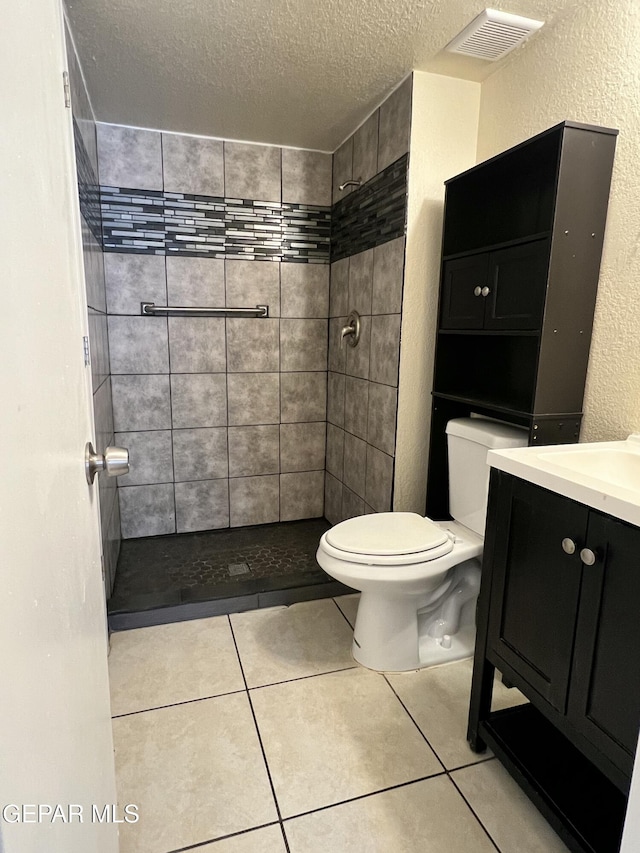 11713 Francis Scobee Dr, El Paso, TX 79936 - full bathroom with a textured ceiling, a shower stall, vanity, tile patterned flooring, and a textured wall