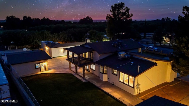 796 Fescue Dr, Canutillo, TX 79835 - back of property at dusk featuring a balcony, stucco siding, a patio area, and a yard