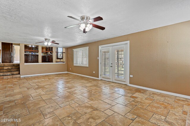 796 Fescue Dr, Canutillo, TX 79835 - unfurnished living room with ceiling fan, a textured ceiling, and stone tile floors