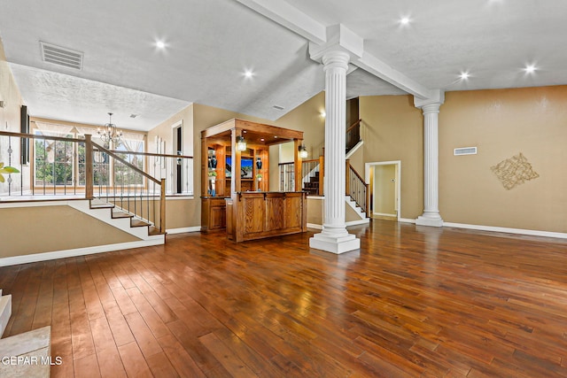796 Fescue Dr, Canutillo, TX 79835 - unfurnished living room featuring stairway, dark wood finished floors, a chandelier, decorative columns, and lofted ceiling