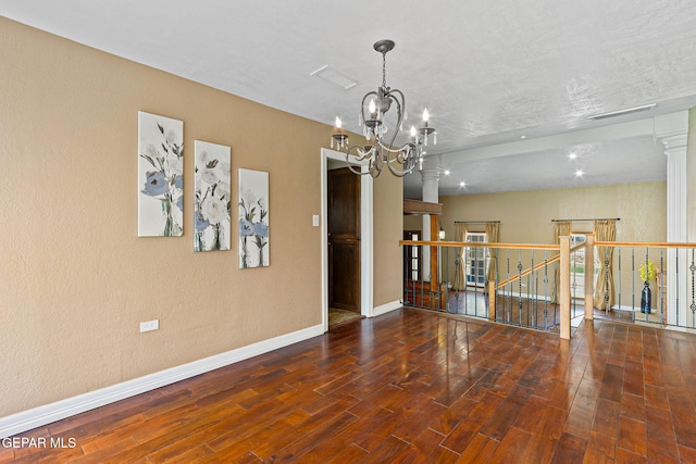 796 Fescue Dr, Canutillo, TX 79835 - spare room with a chandelier, wood finished floors, and ornate columns