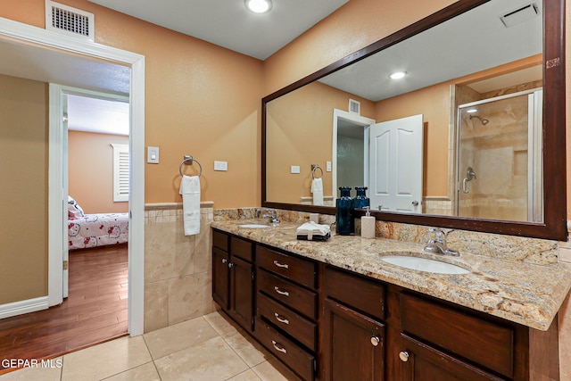 796 Fescue Dr, Canutillo, TX 79835 - bathroom with double vanity, ensuite bathroom, a shower stall, wainscoting, and tile walls