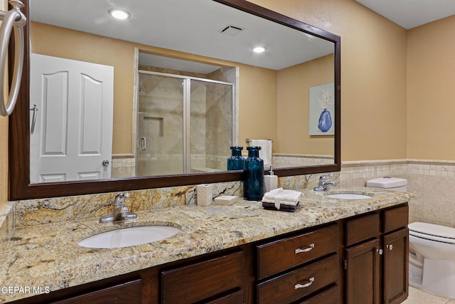 796 Fescue Dr, Canutillo, TX 79835 - full bathroom featuring double vanity, a stall shower, a wainscoted wall, and tile walls