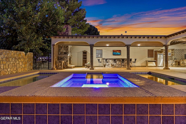 796 Fescue Dr, Canutillo, TX 79835 - pool at dusk with an in-ground hot tub, a patio, and an outdoor pool