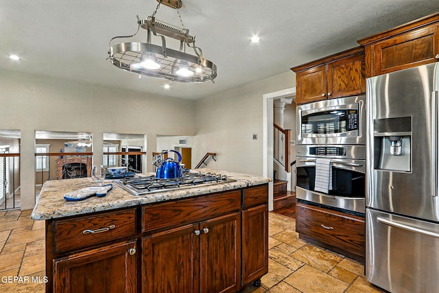 796 Fescue Dr, Canutillo, TX 79835 - kitchen featuring appliances with stainless steel finishes, stone tile floors, recessed lighting, a fireplace, and open floor plan