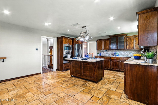 796 Fescue Dr, Canutillo, TX 79835 - kitchen featuring appliances with stainless steel finishes, backsplash, a center island, stone tile floors, and recessed lighting