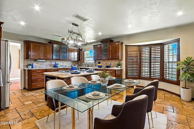 796 Fescue Dr, Canutillo, TX 79835 - kitchen with stone tile flooring, decorative backsplash, a center island, recessed lighting, and glass insert cabinets