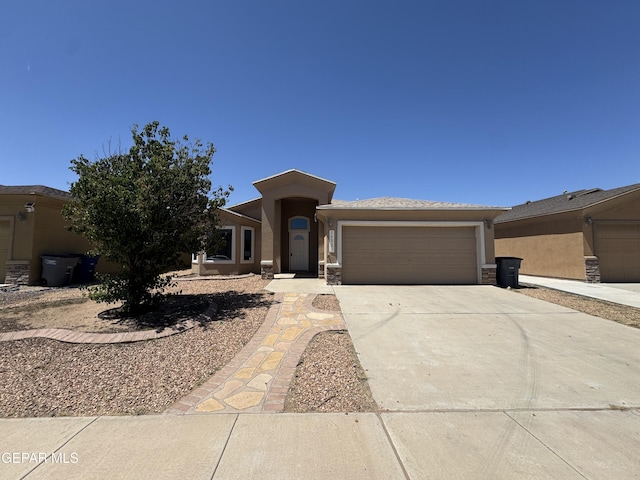 14325 Woods Point Ave, El Paso, TX 79938 - view of front of property with stucco siding, a garage, driveway, and stone siding