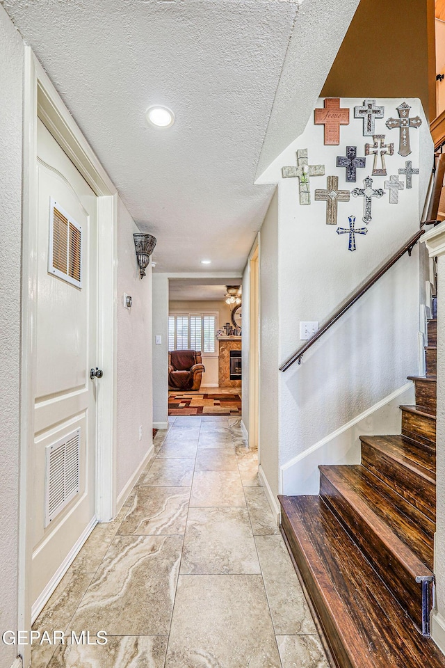 7366 Luz De Dia Ct, El Paso, TX 79912 - corridor featuring stairway and a textured ceiling