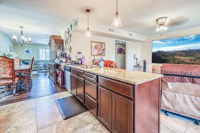 7366 Luz De Dia Ct, El Paso, TX 79912 - kitchen with open floor plan, light stone countertops, hanging light fixtures, ceiling fan, and a chandelier