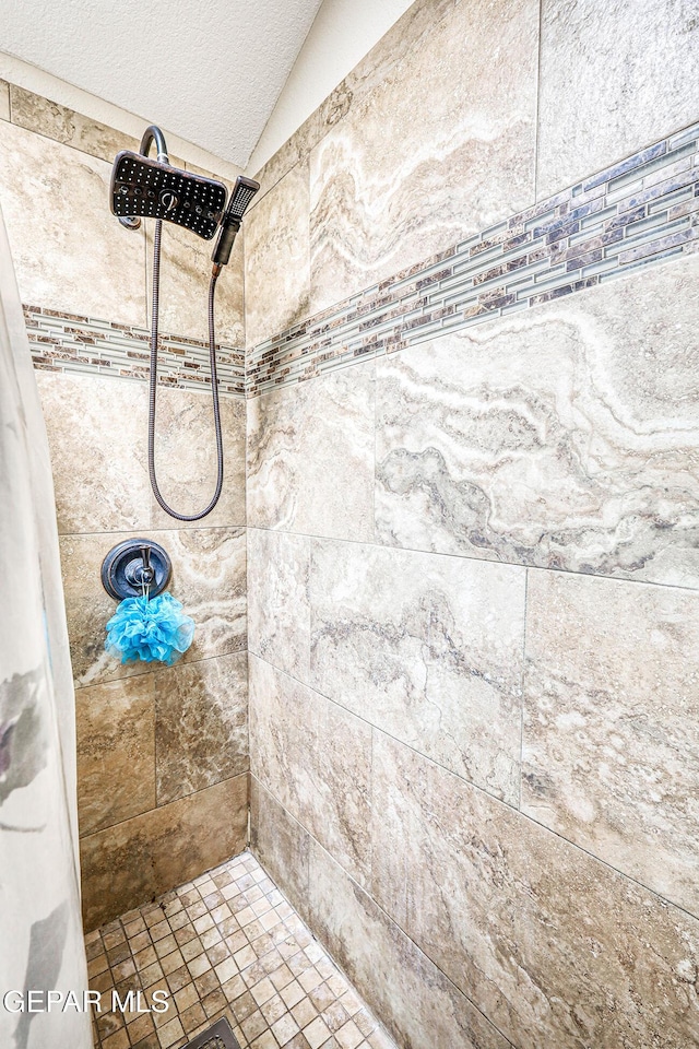 7366 Luz De Dia Ct, El Paso, TX 79912 - full bathroom with tiled shower, vaulted ceiling, and a textured ceiling