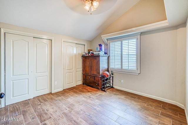 7366 Luz De Dia Ct, El Paso, TX 79912 - bedroom with two closets, wood finished floors, vaulted ceiling, and a ceiling fan