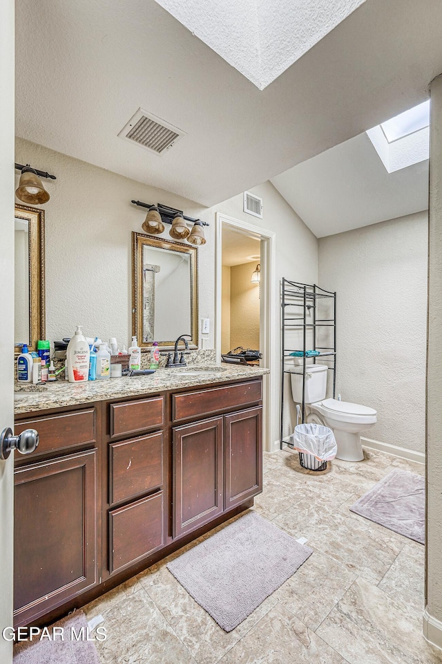 7366 Luz De Dia Ct, El Paso, TX 79912 - bathroom with a skylight, vanity, stone finish flooring, and a textured wall