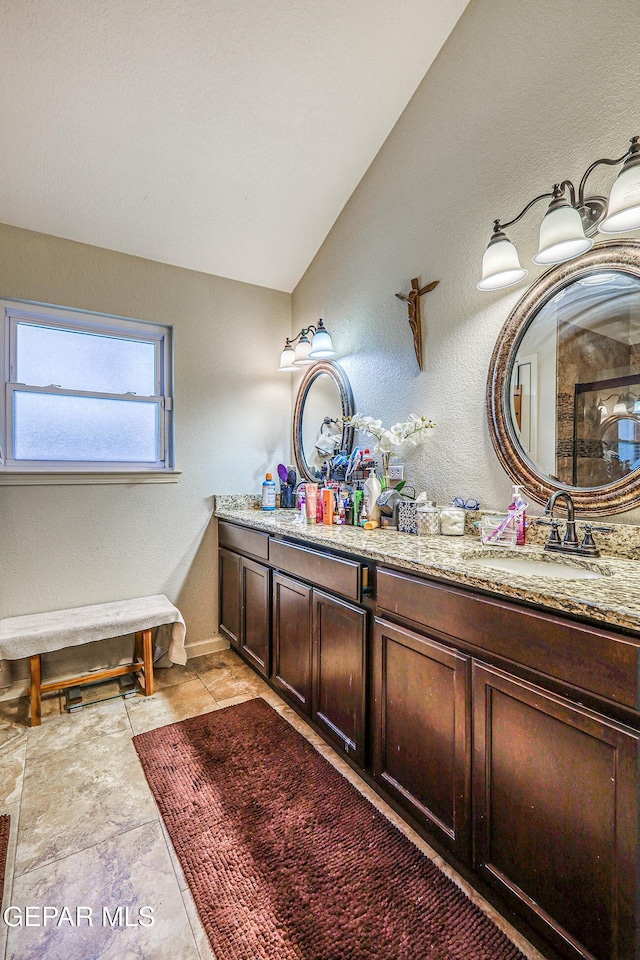 7366 Luz De Dia Ct, El Paso, TX 79912 - full bath with double vanity, lofted ceiling, and a textured wall