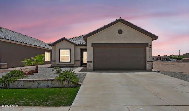 13860 Paseo Sereno Dr, El Paso, TX 79928 - view of front of house with a garage, a tile roof, driveway, stucco siding, and stone siding