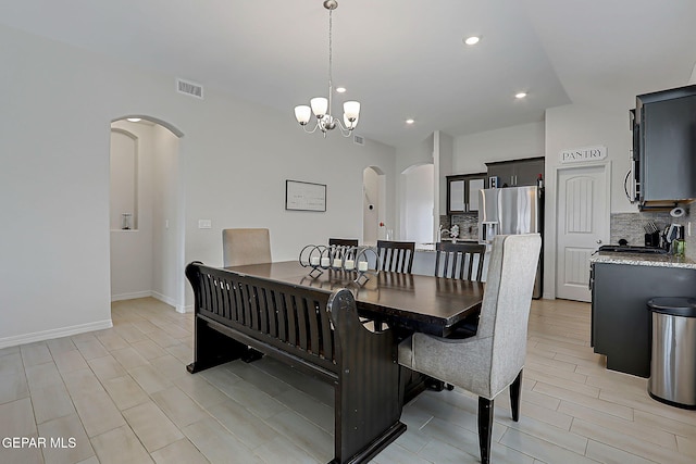 13860 Paseo Sereno Dr, El Paso, TX 79928 - dining space featuring arched walkways, a chandelier, recessed lighting, vaulted ceiling, and light wood-style floors