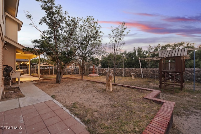 5713 Saplinas Rd, El Paso, TX 79932 - yard at dusk with a patio area and a playground