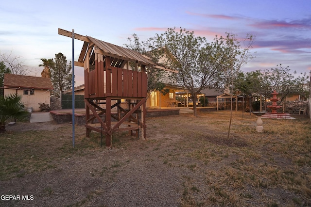 5713 Saplinas Rd, El Paso, TX 79932 - playground at dusk featuring an outbuilding