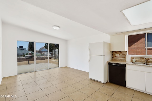 241 Mardi Gras Dr, El Paso, TX 79912 - kitchen featuring dishwasher, freestanding refrigerator, white cabinetry, light tile patterned flooring, and vaulted ceiling