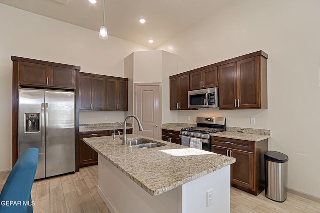7825 Enchanted View Dr, El Paso, TX 79911 - kitchen with appliances with stainless steel finishes, wood tiled floors, dark brown cabinetry, light stone counters, and recessed lighting