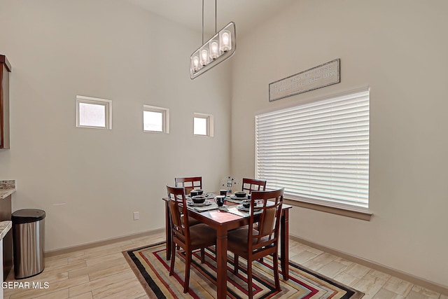 7825 Enchanted View Dr, El Paso, TX 79911 - dining room featuring plenty of natural light, light wood finished floors, and a towering ceiling
