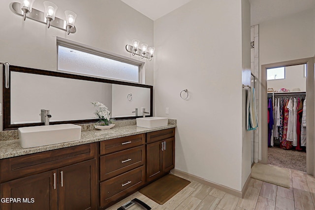 7825 Enchanted View Dr, El Paso, TX 79911 - bathroom featuring double vanity, wood finish floors, and a spacious closet