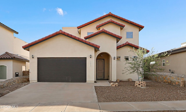 7825 Enchanted View Dr, El Paso, TX 79911 - mediterranean / spanish-style home featuring a garage, concrete driveway, a tile roof, and stucco siding
