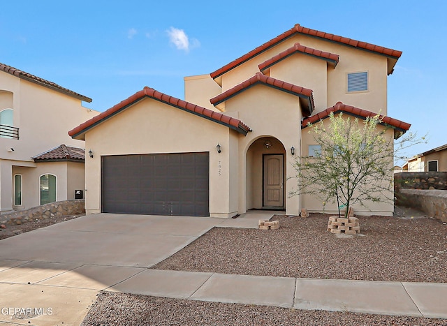 7825 Enchanted View Dr, El Paso, TX 79911 - mediterranean / spanish-style house featuring a tiled roof, an attached garage, concrete driveway, and stucco siding