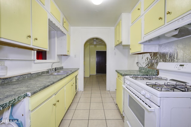 1268 Stanley St, El Paso, TX 79907 - kitchen with gas range gas stove, under cabinet range hood, a ceiling fan, light tile patterned flooring, and dark countertops