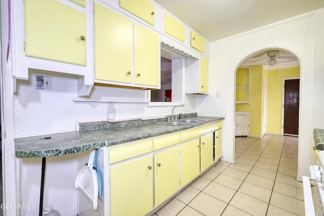 1268 Stanley St, El Paso, TX 79907 - kitchen with light tile patterned floors, arched walkways, ceiling fan, and dark countertops