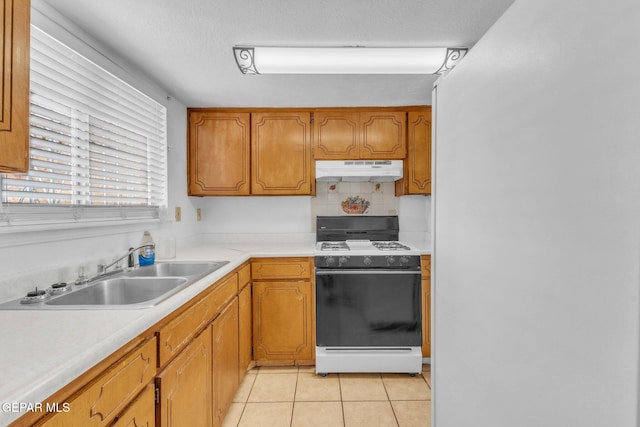 8763 Cathedral Cir, El Paso, TX 79907 - kitchen with white range with gas stovetop, under cabinet range hood, light tile patterned floors, and light countertops