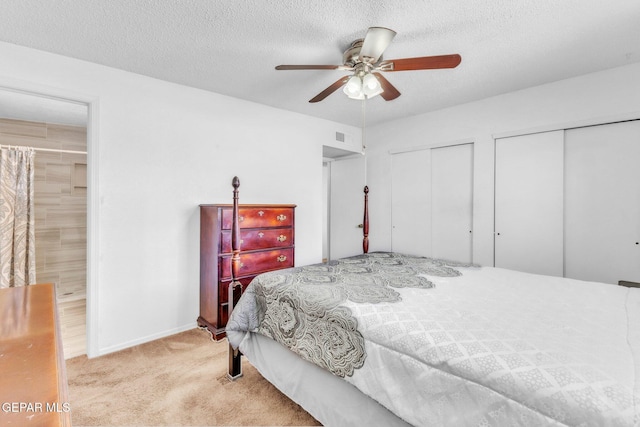 8763 Cathedral Cir, El Paso, TX 79907 - carpeted bedroom with multiple closets, a textured ceiling, ceiling fan, and connected bathroom