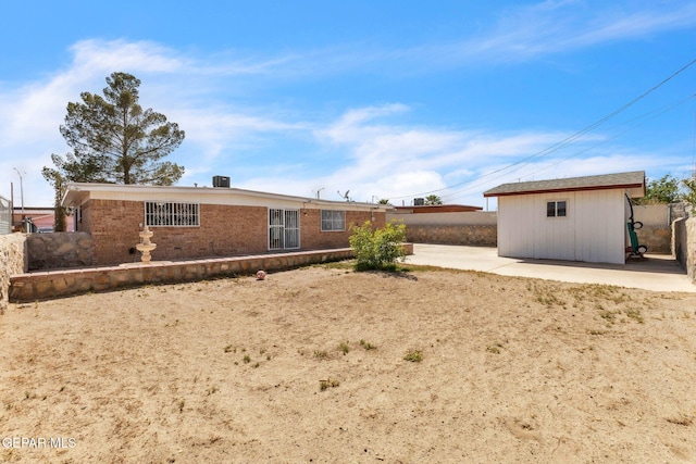 8763 Cathedral Cir, El Paso, TX 79907 - back of house featuring a patio area, brick siding, and an outbuilding