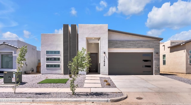 13829 Summer View Ave, Horizon City, TX 79928 - contemporary house featuring concrete driveway, a garage, stone siding, and stucco siding