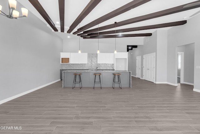 13829 Summer View Ave, Horizon City, TX 79928 - kitchen with tasteful backsplash, white cabinetry, a breakfast bar, beam ceiling, and hanging light fixtures