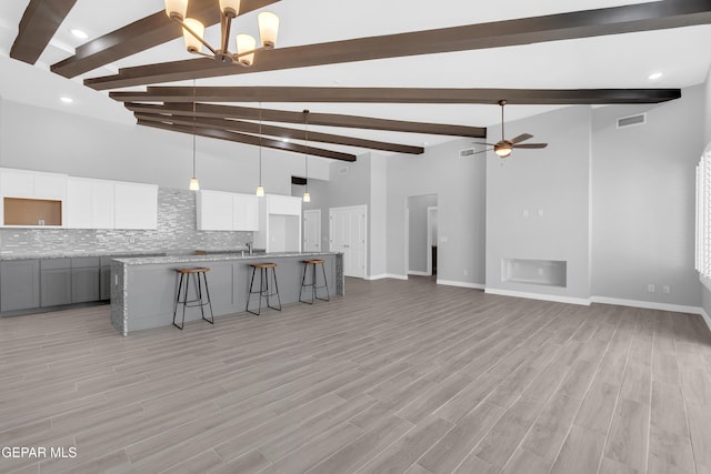 13829 Summer View Ave, Horizon City, TX 79928 - unfurnished living room with beam ceiling, a ceiling fan, light wood-type flooring, a chandelier, and recessed lighting