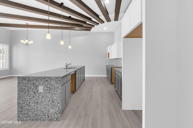 13829 Summer View Ave, Horizon City, TX 79928 - kitchen with light stone countertops, white cabinets, beamed ceiling, light wood finished floors, and recessed lighting