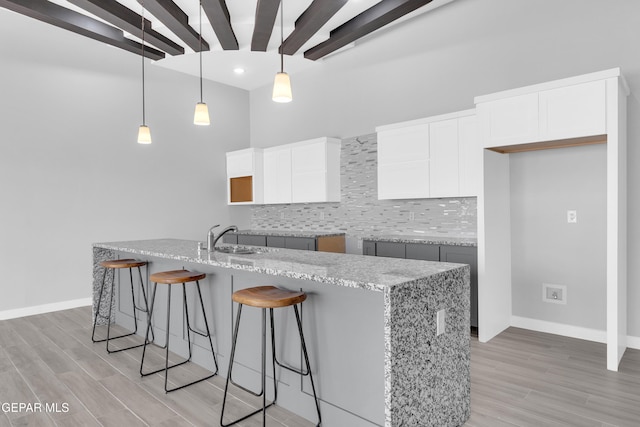 13829 Summer View Ave, Horizon City, TX 79928 - kitchen with decorative backsplash, a kitchen breakfast bar, light wood-style flooring, light stone countertops, and recessed lighting