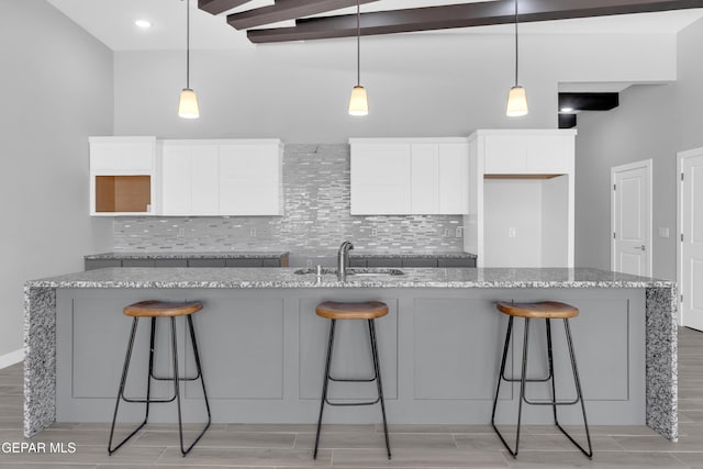 13829 Summer View Ave, Horizon City, TX 79928 - kitchen with white cabinets, tasteful backsplash, wood finish floors, and light stone countertops