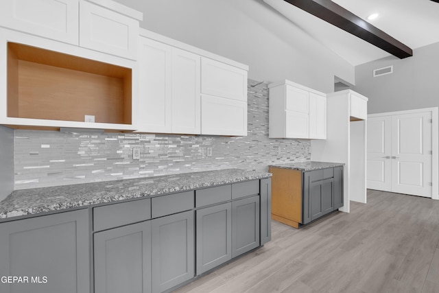 13829 Summer View Ave, Horizon City, TX 79928 - kitchen with gray cabinets, tasteful backsplash, light wood-style floors, white cabinets, and light stone counters