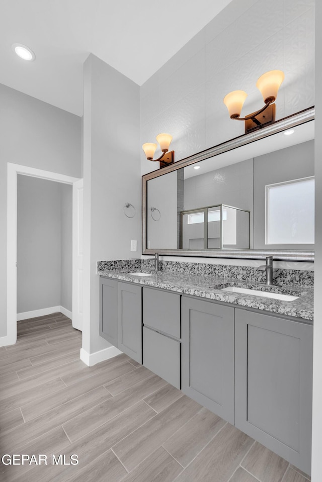 13829 Summer View Ave, Horizon City, TX 79928 - bathroom with double vanity, wood finished floors, and recessed lighting