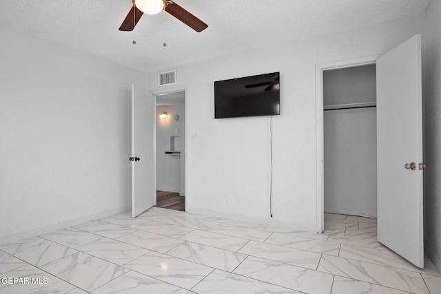 1400 Elmhurst Dr, El Paso, TX 79925 - unfurnished bedroom featuring a closet, light marble finish flooring, a textured ceiling, and ceiling fan