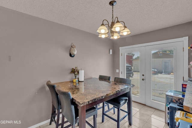 dining area featuring french doors, a chandelier, light tile patterned floors, and a textured ceiling