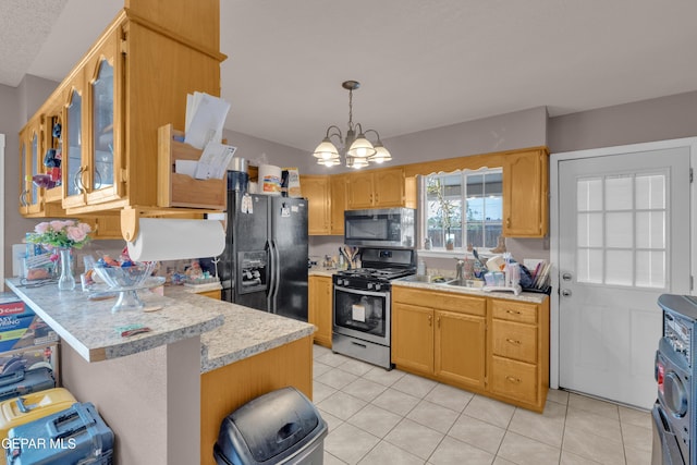 kitchen with stainless steel appliances, light countertops, a peninsula, and light tile patterned floors