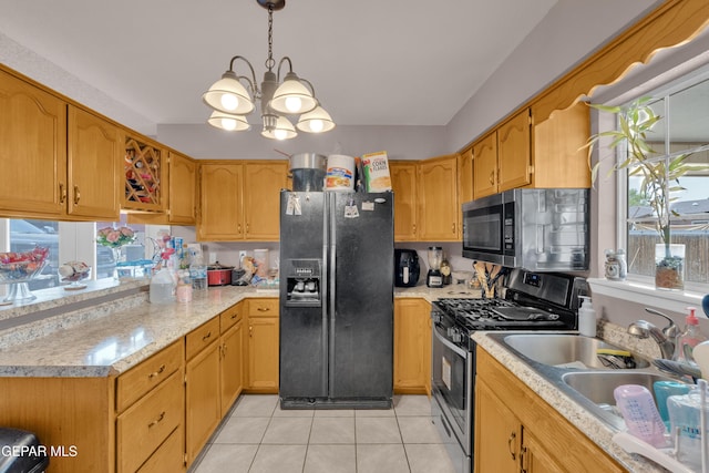 kitchen featuring stainless steel appliances, a chandelier, light countertops, light tile patterned floors, and hanging light fixtures