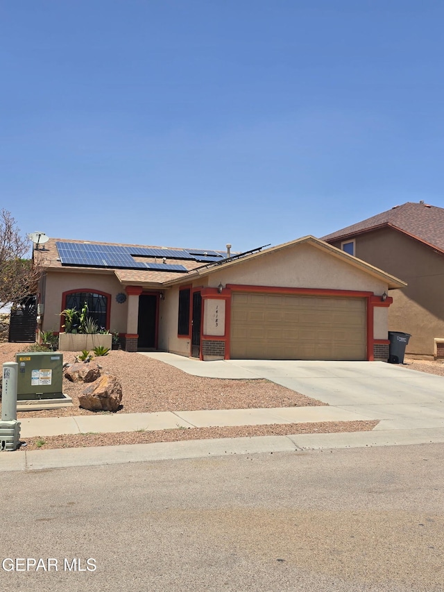 14185 Silver Point Ave, El Paso, TX 79938 - ranch-style house featuring a garage, driveway, roof mounted solar panels, and stucco siding