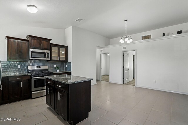 12469 Lanchester Dr, El Paso, TX 79928 - kitchen with stainless steel appliances, backsplash, dark stone counters, a center island, and a chandelier