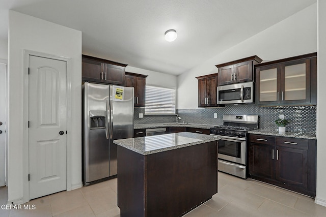 12469 Lanchester Dr, El Paso, TX 79928 - kitchen featuring stainless steel appliances, decorative backsplash, dark brown cabinetry, light tile patterned floors, and vaulted ceiling