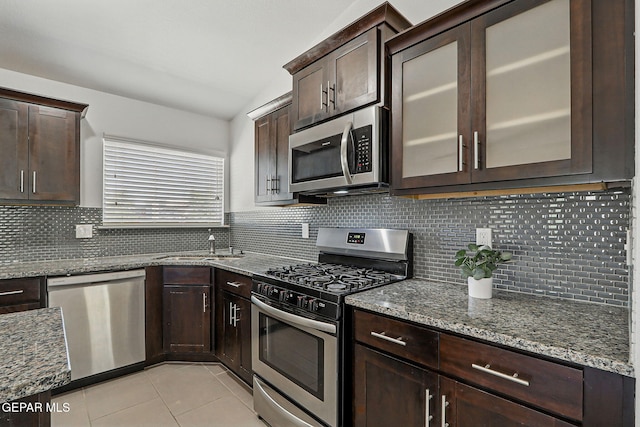 12469 Lanchester Dr, El Paso, TX 79928 - kitchen featuring stainless steel appliances, stone countertops, dark brown cabinets, light tile patterned flooring, and backsplash